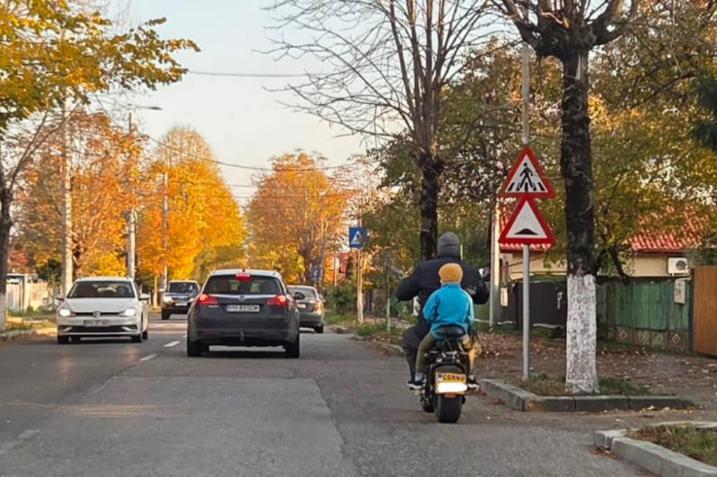 Iresponsabilitate. Cu un copil pe moped, fără cască...